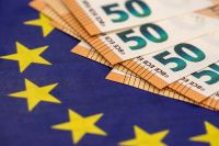 Foto: Geldscheine und Europaflagge