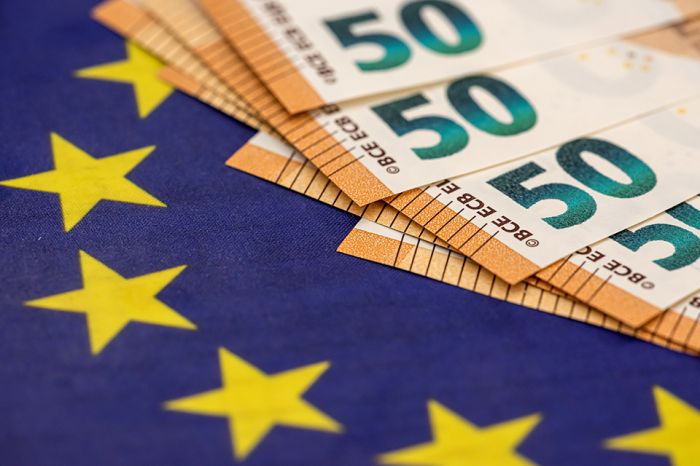 Foto: Geldscheine und Europaflagge